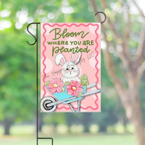Bunny Spring Yard Flag displayed outdoors, standing out in a garden setting. "Bloom Where You Are Planted"